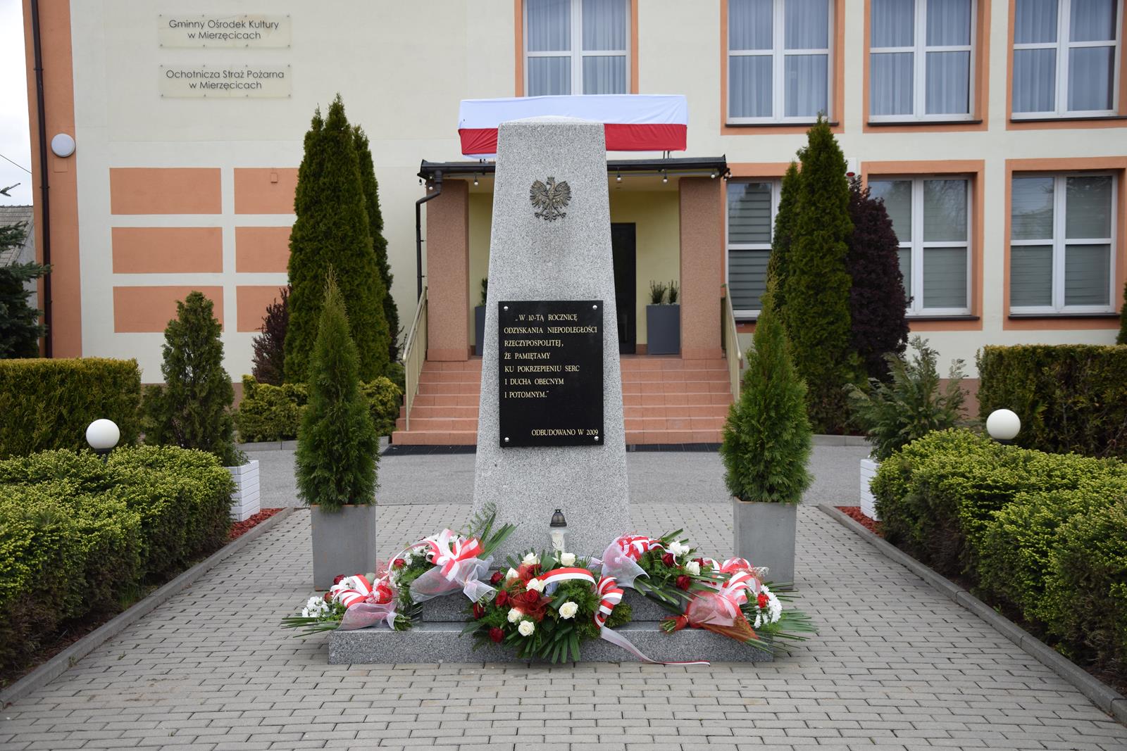 Pomnik 10-lecia odzyskania niepodległości ze złożonymi kwiatami
