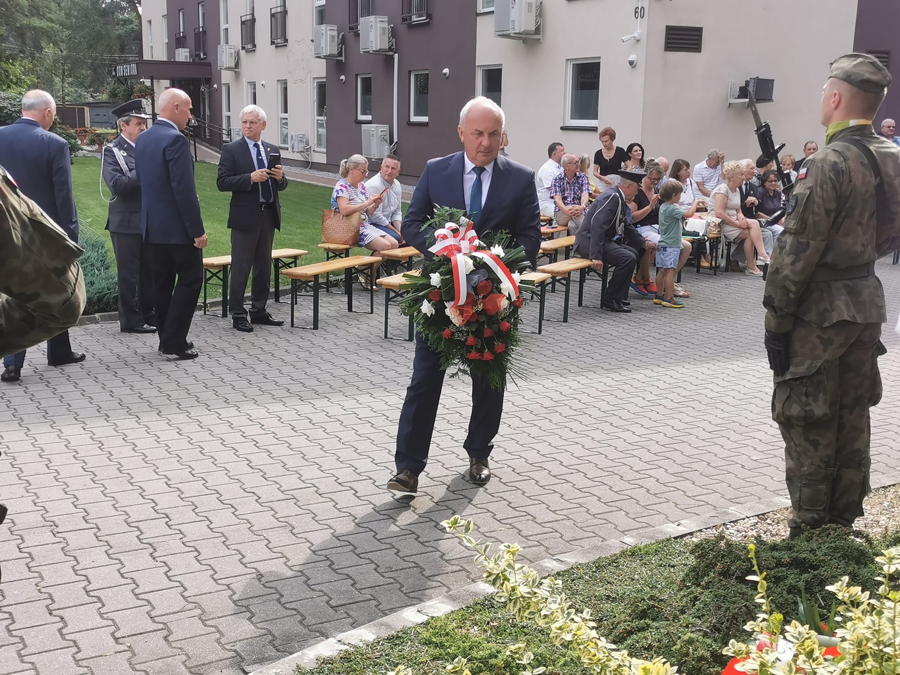 Zdjęcie przedstawiające składanie kwiatów pod pomnikiem przez Wójta Gminy Mierzęcice Grzegorza Podlejskiego