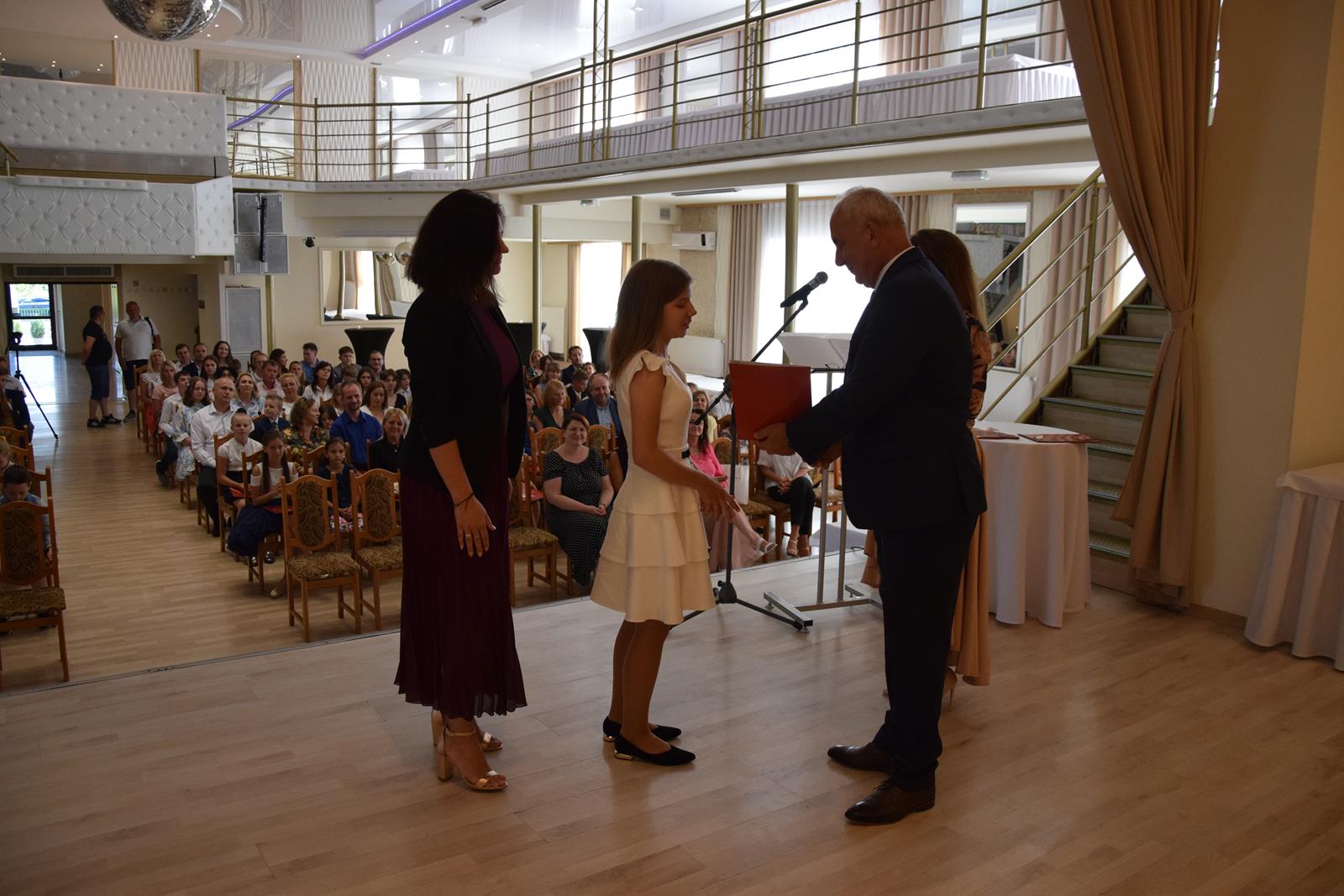 Zdjęcie przedstawiające moment rozdania nagród za wybite osiągnięcia i średnią ocen powyżej 5,2. Nagrody wręczali Wójt Gminy Mierzęcice Grzegorz Podlejski oraz Zastępca Wójta Gminy Mierzęcice Iwona Pańta.